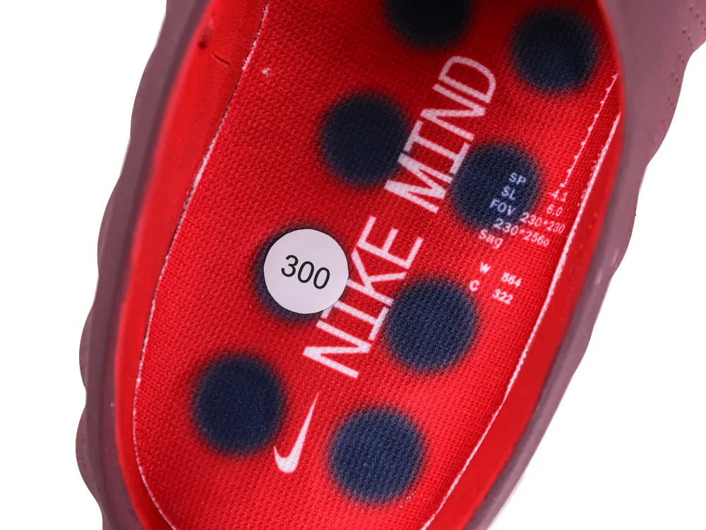 Interior view of the red insole featuring "NIKE MIND" branding and dark circular patterns.