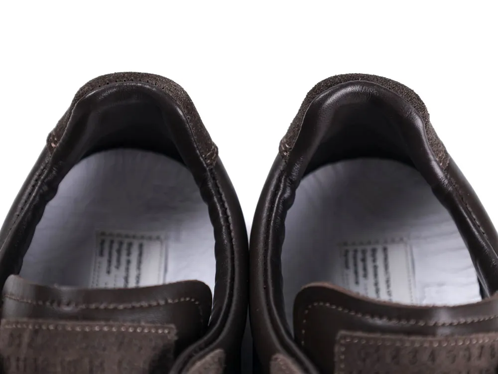 Close-up of brown leather shoe interiors showing detailed stitching and insoles.