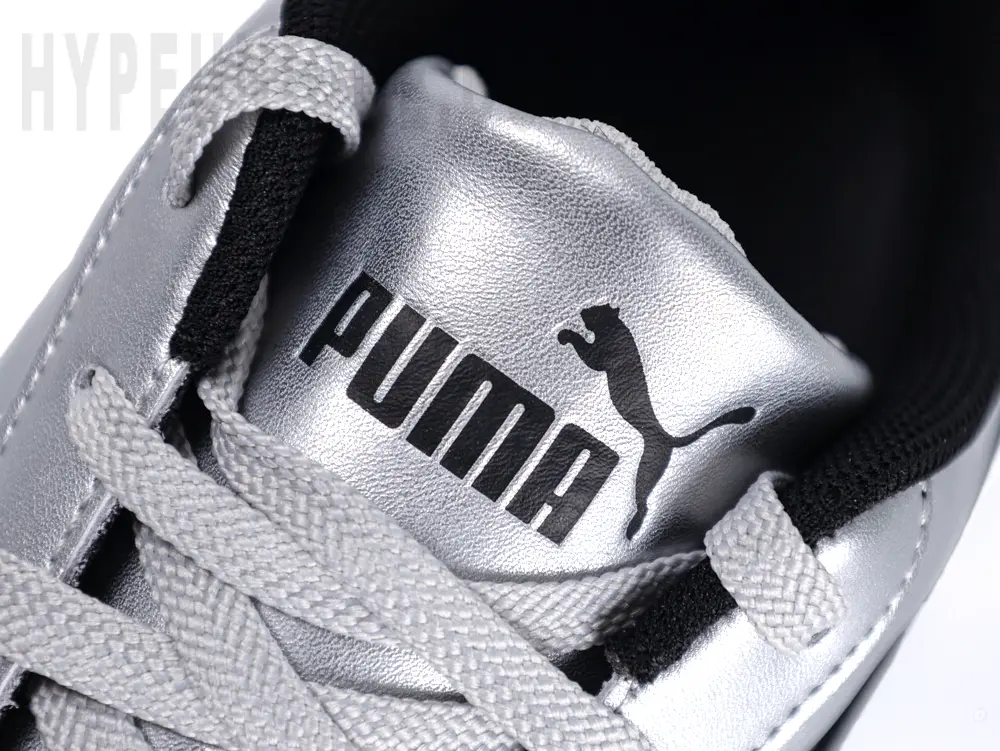Detail view of the Puma Speedcat ‘Metallic Silver’ tongue, featuring a silver tongue and black Puma logo.
