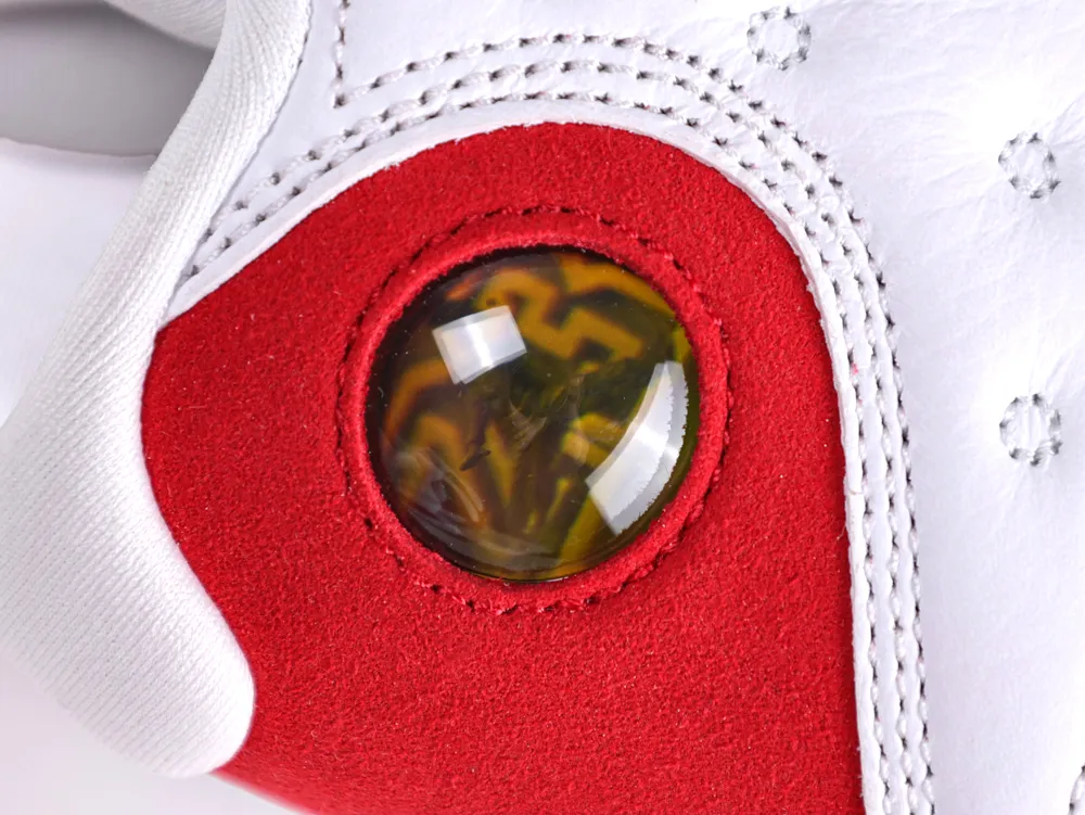 Close-up of a red suede sneaker with white leather and a translucent detail.