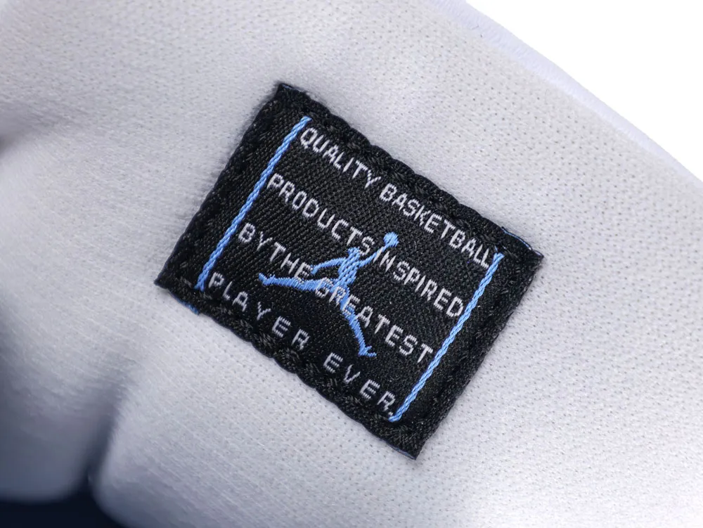 Black fabric label with blue logo on white textile surface.