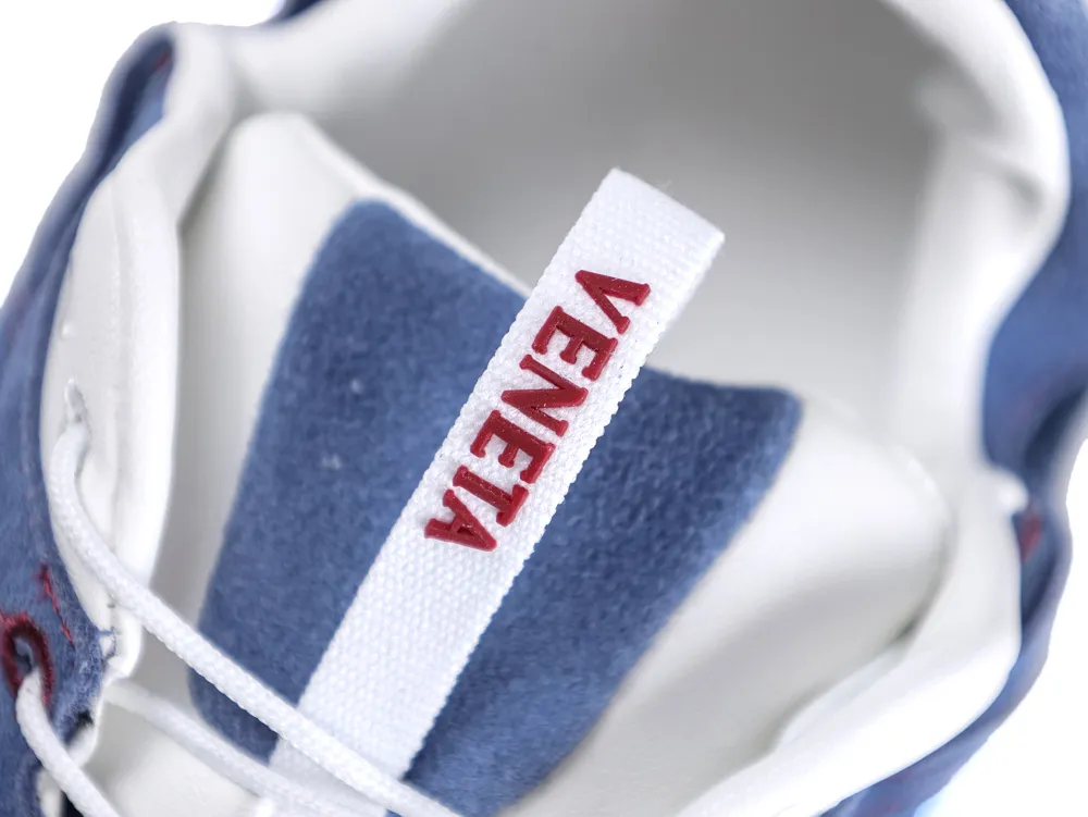 Blue suede sneaker with white leather interior and white fabric tongue label.