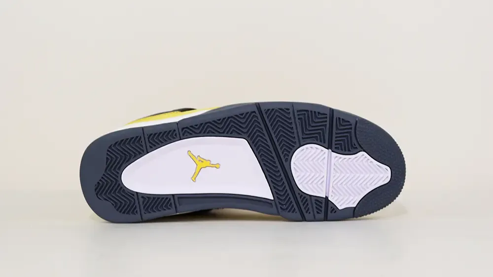 A bottom view of the Jordan 4 Retro ‘Lightning’ (2021), showcasing its black and white rubber outsole