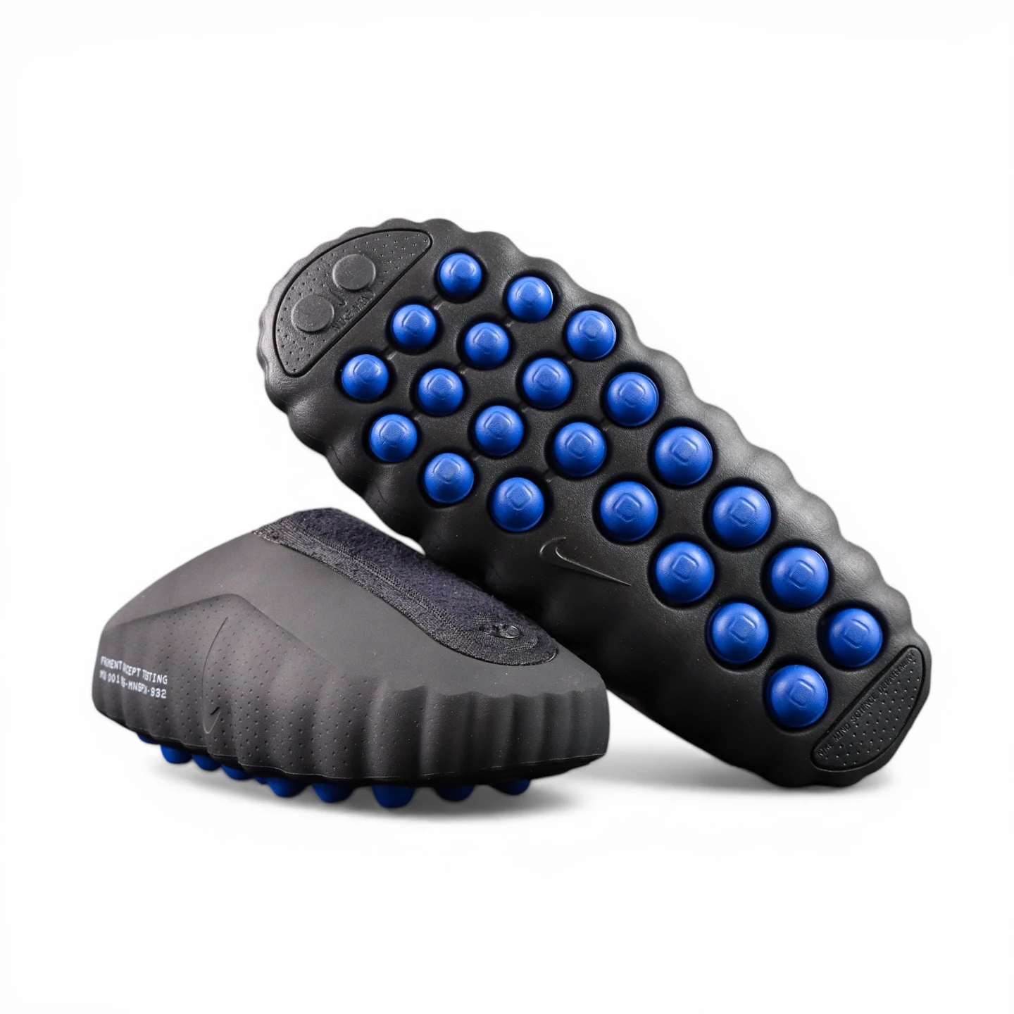 Gray shoe with textured rubber sole, featuring prominent blue circular grips.