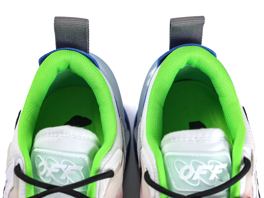 Close-up of sneakers with green fabric lining, gray pull tabs, and white tongues.