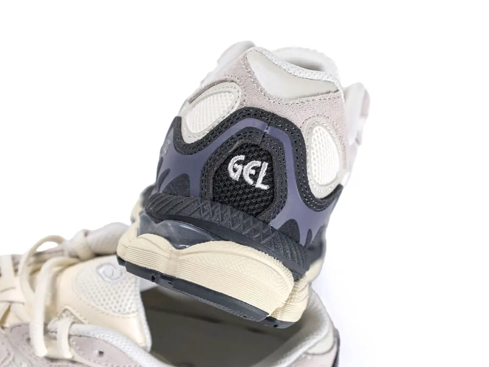 Beige and gray sneaker with mesh and suede material, featuring "GEL" on the heel.