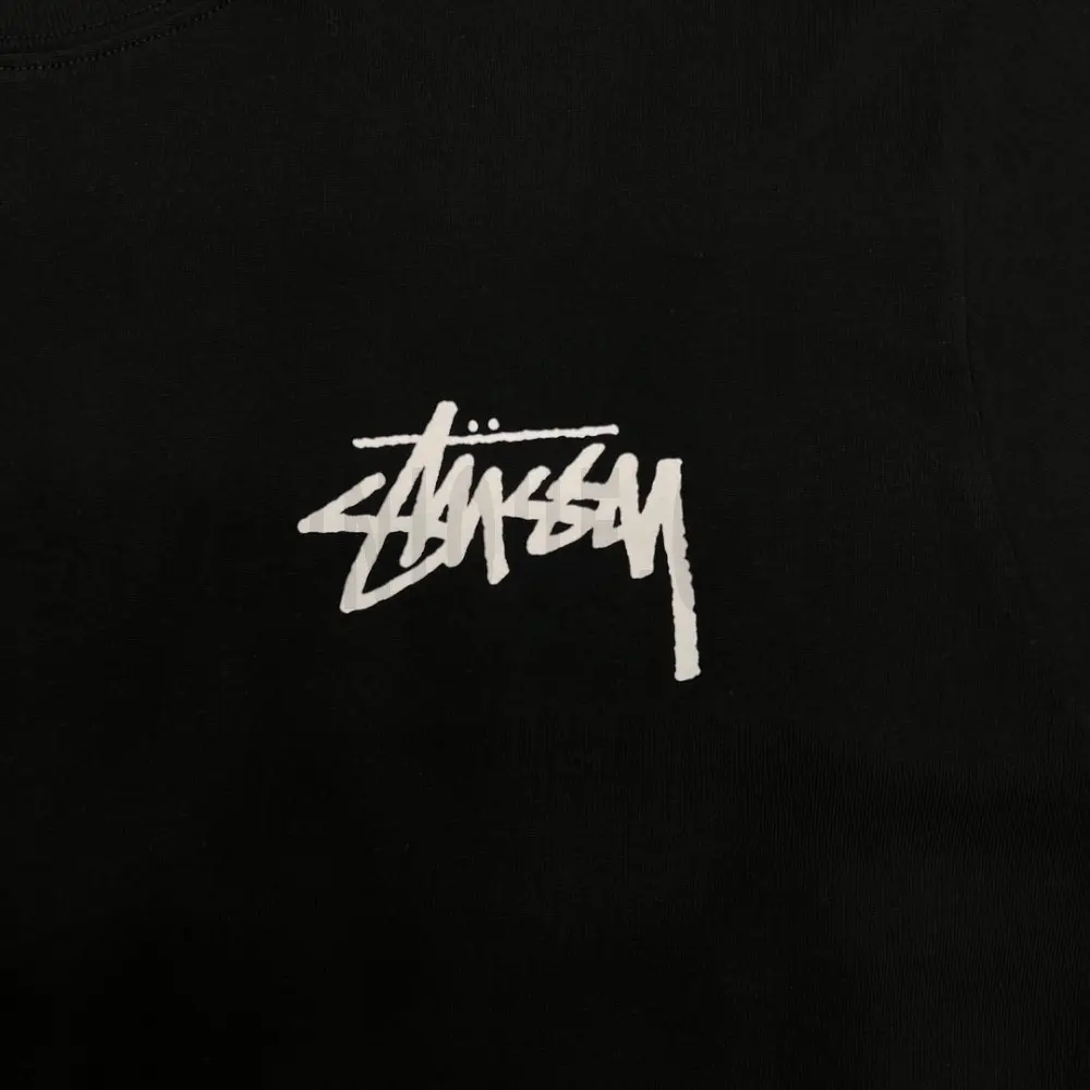 Detailed shot capturing the graphic print on the black tee's front panel.