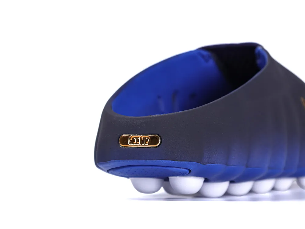 Rear view of the slip-on shoe highlighting the navy blue upper, royal blue midsole, and white pod traction.