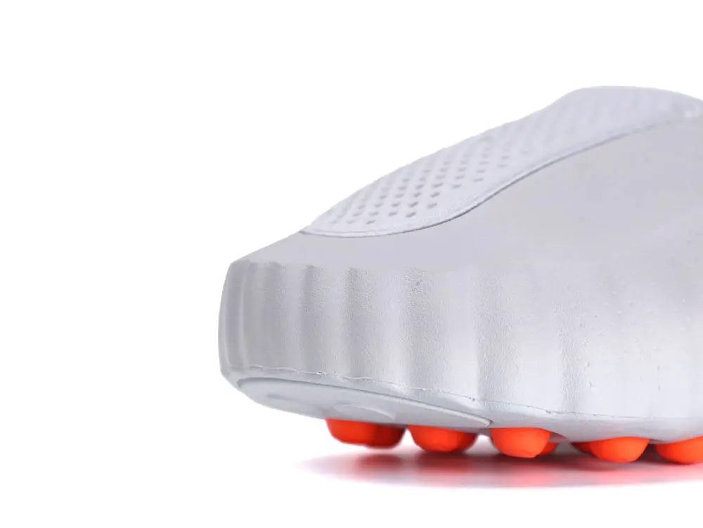 Gray rubber shoe sole with textured grip and bright orange studs.