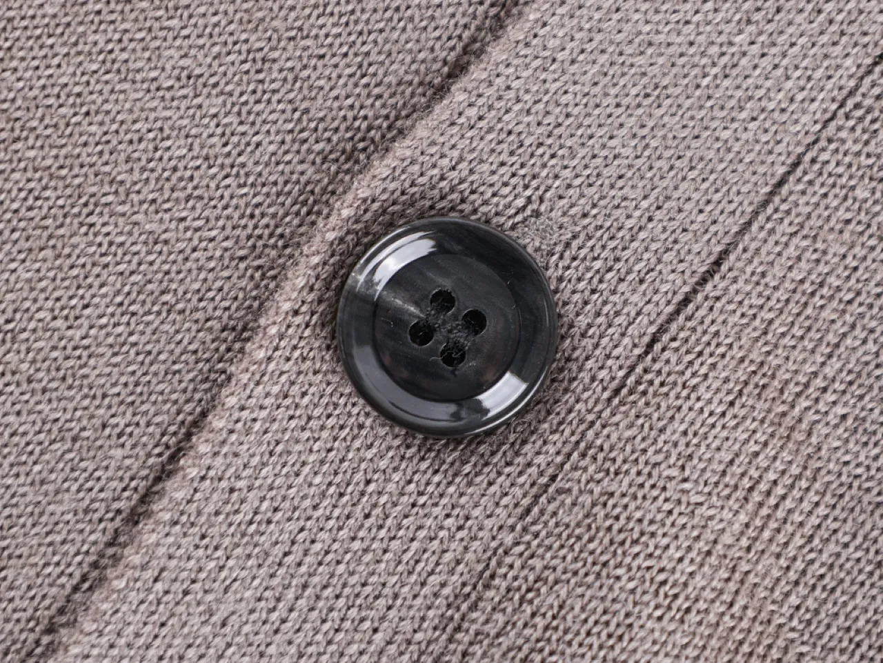 Button on textured knitted fabric garment.