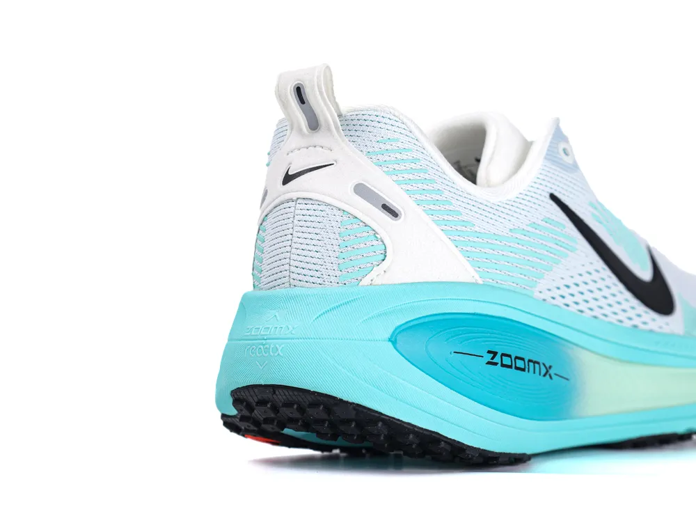 White and teal athletic shoe with mesh upper and black logo on the heel.