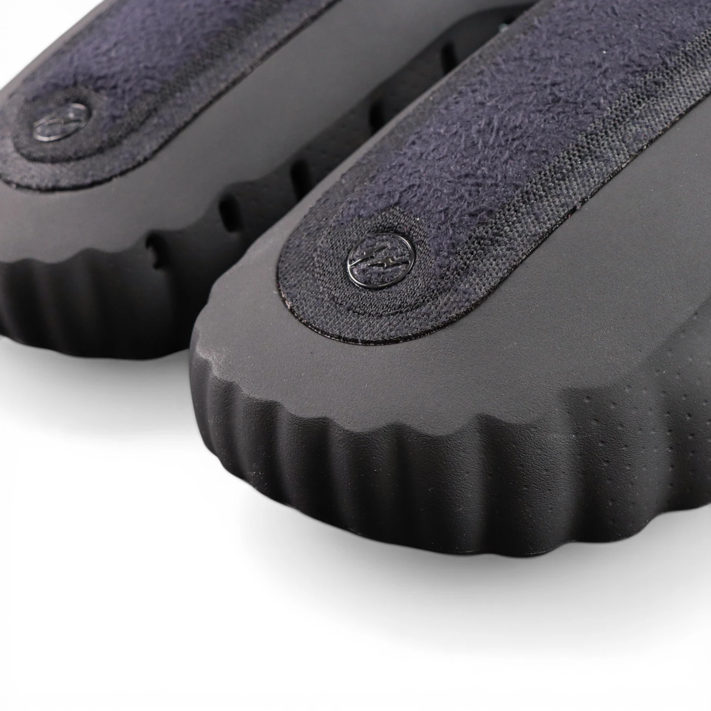 Black and dark blue shoe soles with textured rubber and suede material.