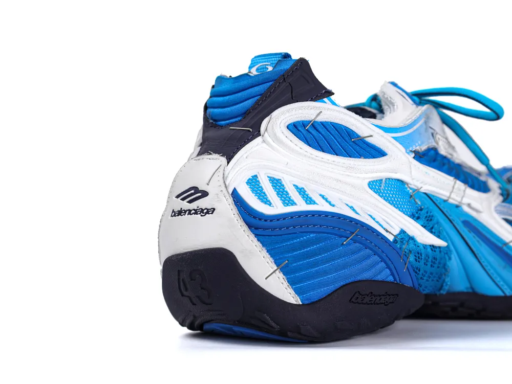 Blue and white sneaker with mixed materials and visible stitching on the heel.