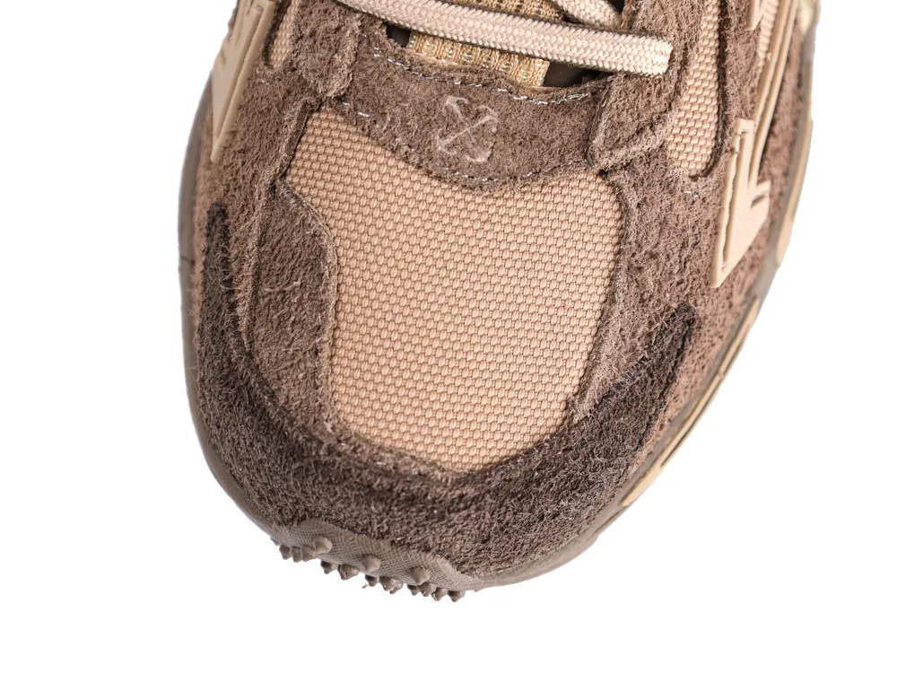 Close-up of a brown suede and mesh sneaker toe section with beige accents.