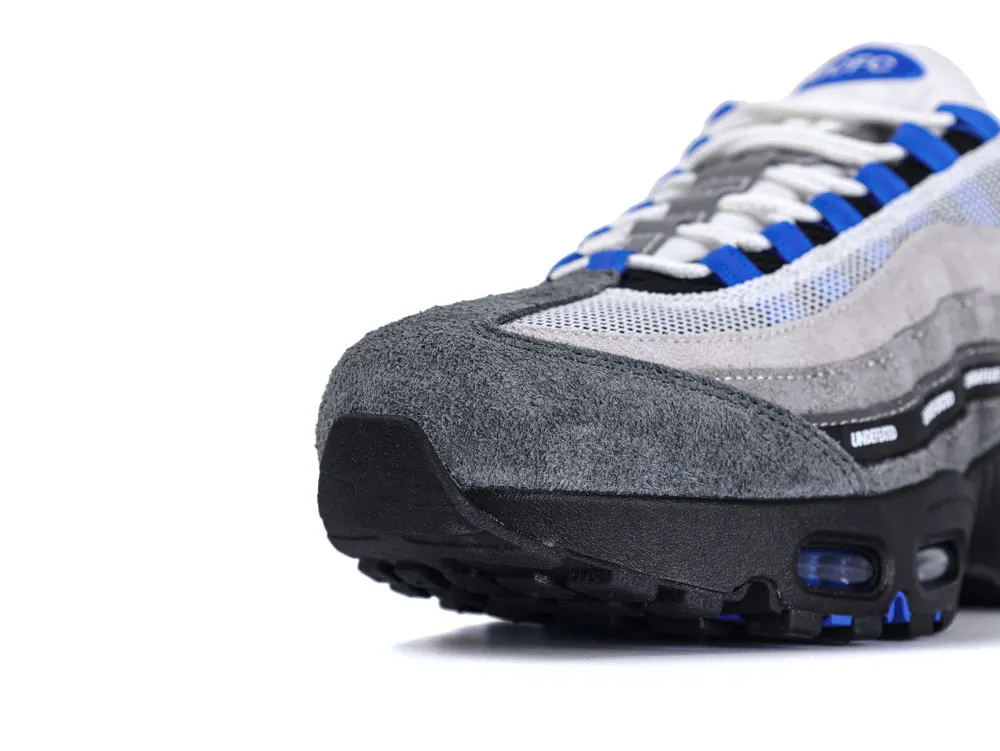 Grey suede sneaker with black sole, blue and white mesh details.