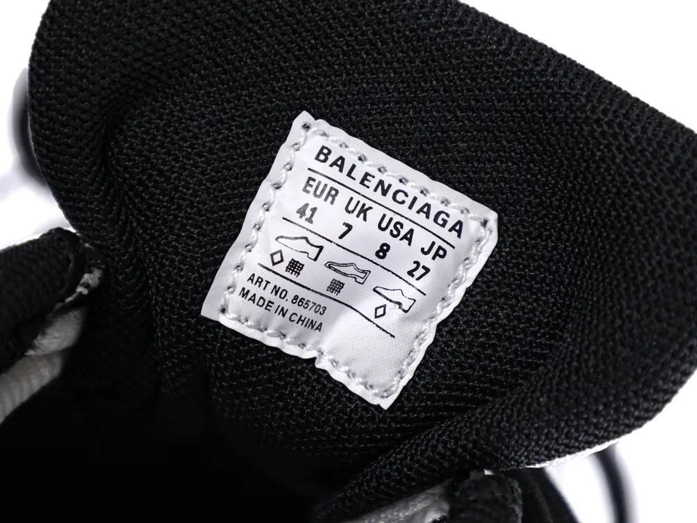 White fabric label with black text on black mesh shoe tongue.