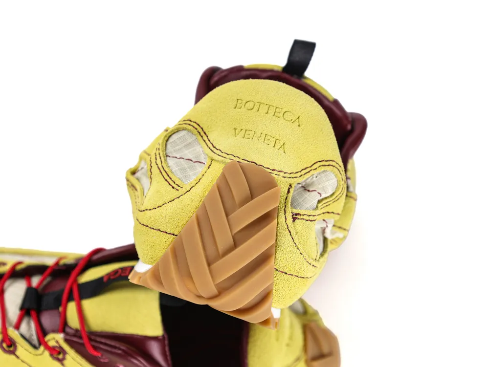 Yellow suede shoe with leather accents and rubber tread detailing.