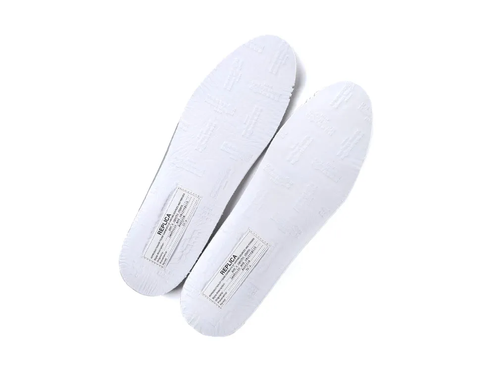 White rubber shoe insoles with embossed text and printed labels.