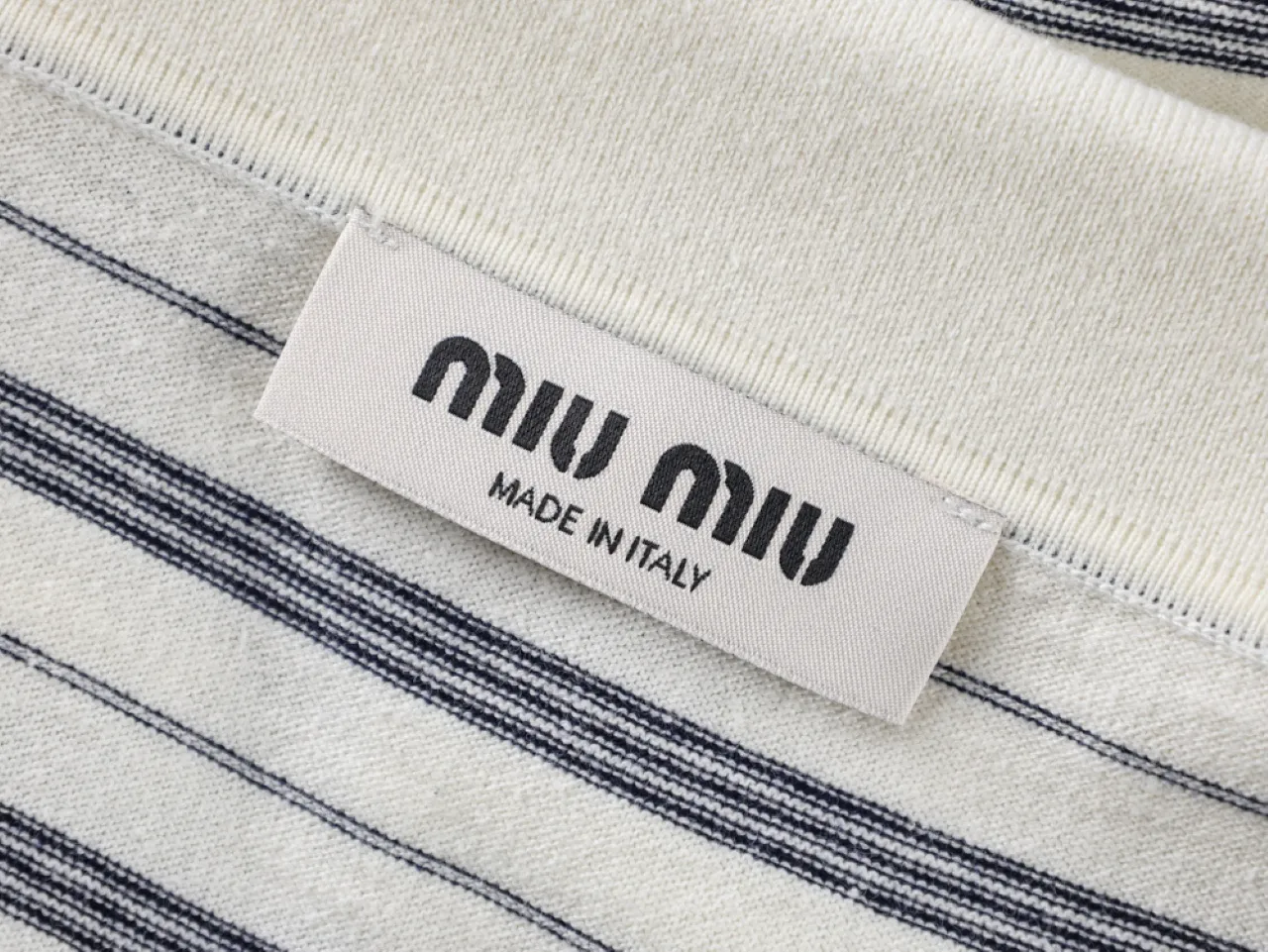 White and navy striped cotton fabric with woven label from neck area.
