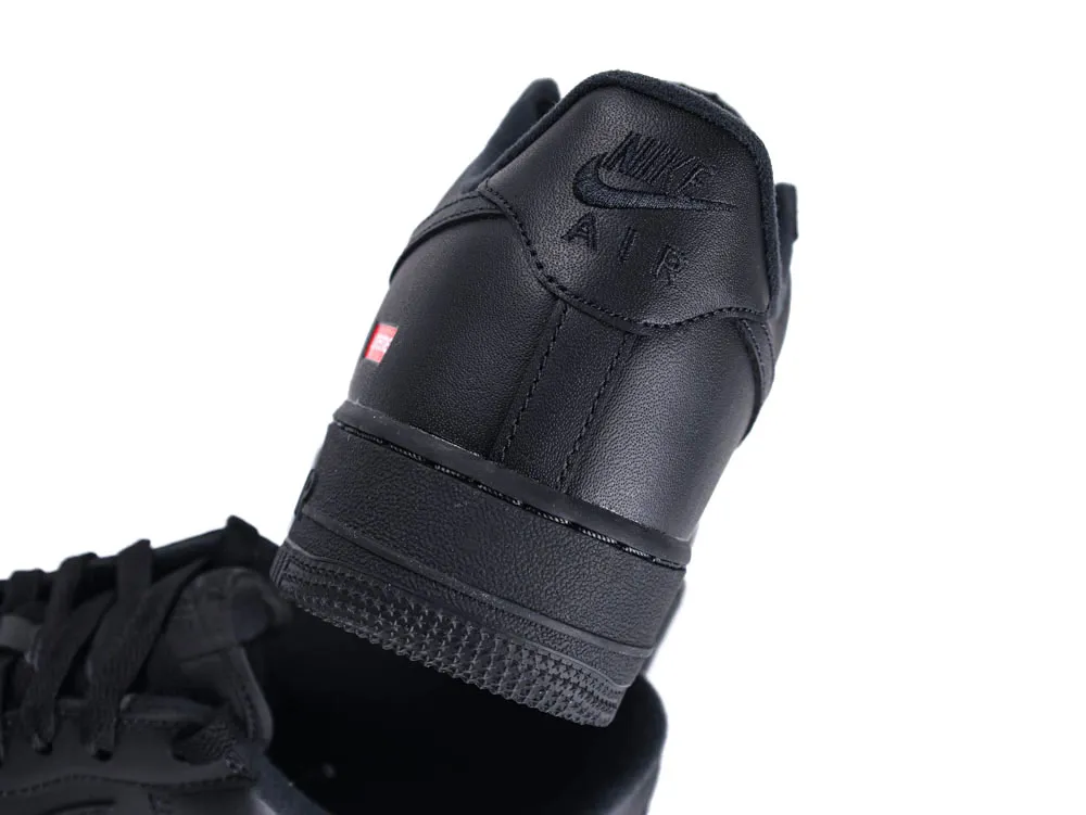 Black leather sneaker with embossed logo on the heel, featuring textured sole.