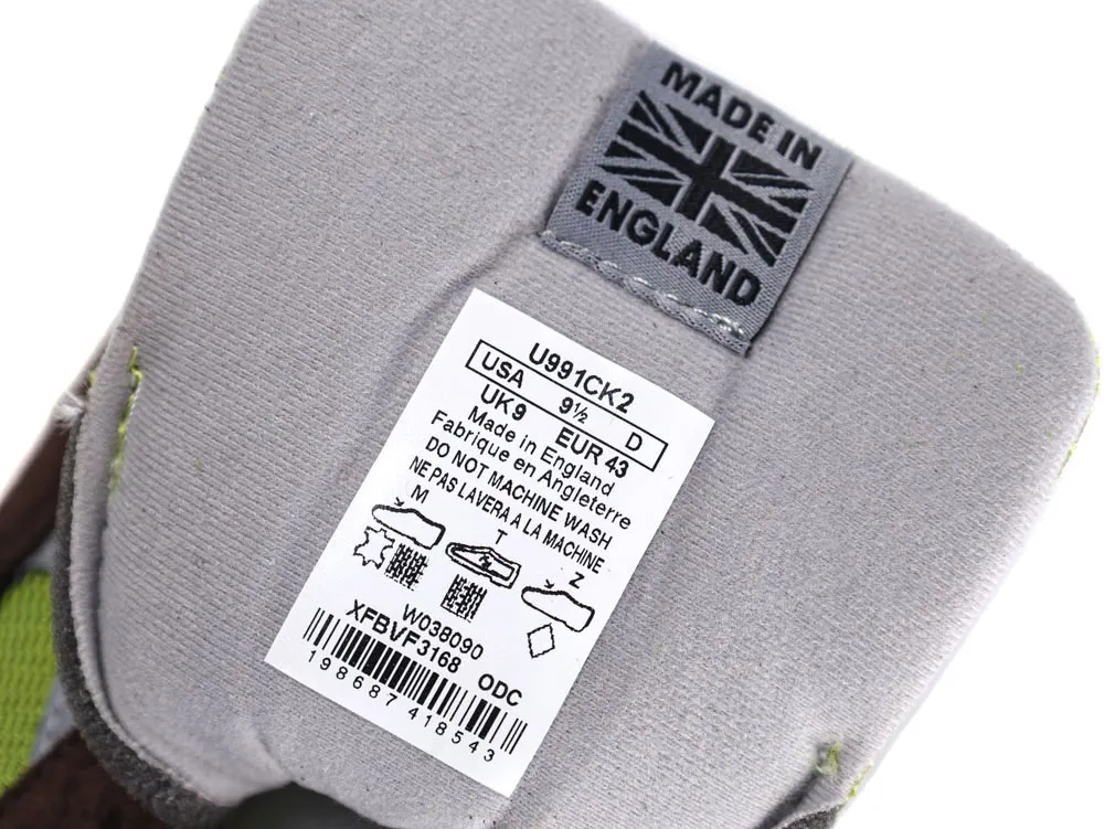 Gray fabric shoe tongue with stitched label showing manufacturing details and washing instructions.