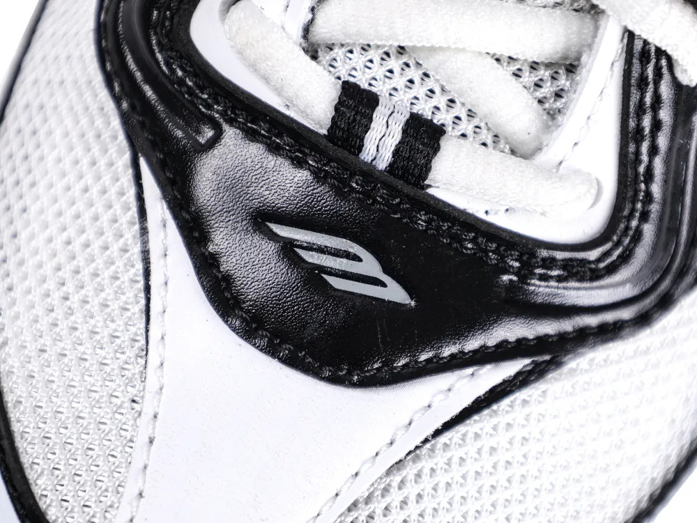 Close-up of a black and white mesh and leather sneaker with laces.