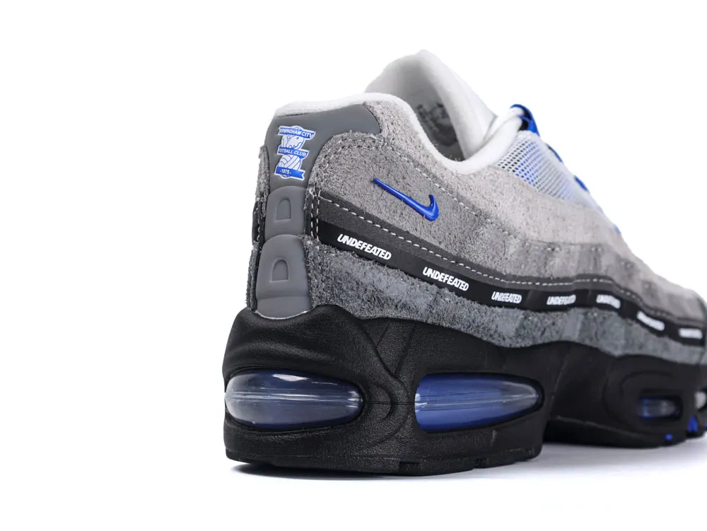 Gray and blue suede sneaker with textured sole and mesh detailing.