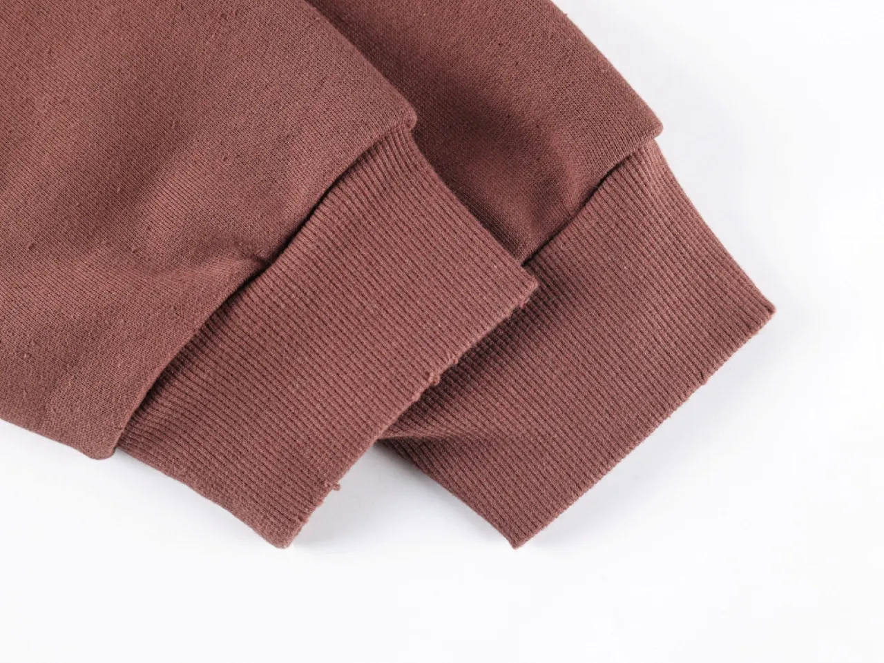 Brown cotton sweatshirt sleeves with ribbed cuffs.