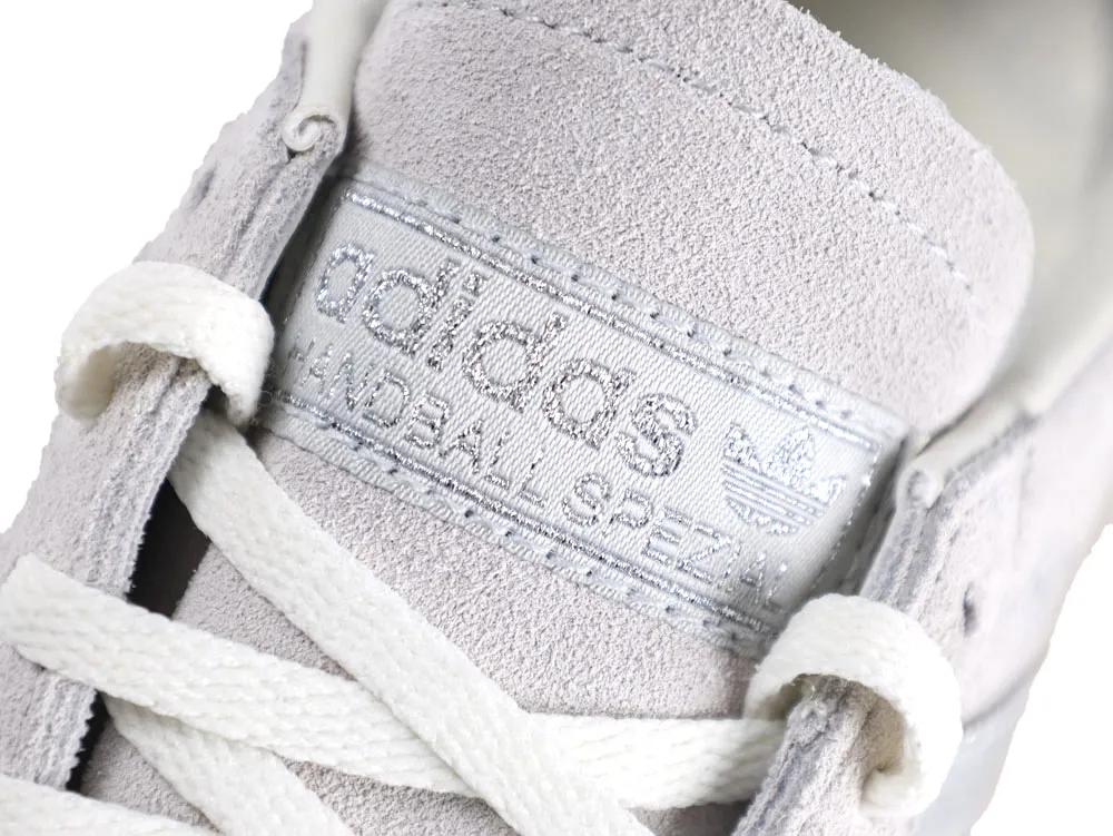 Gray suede shoe with white laces and textured label on top.