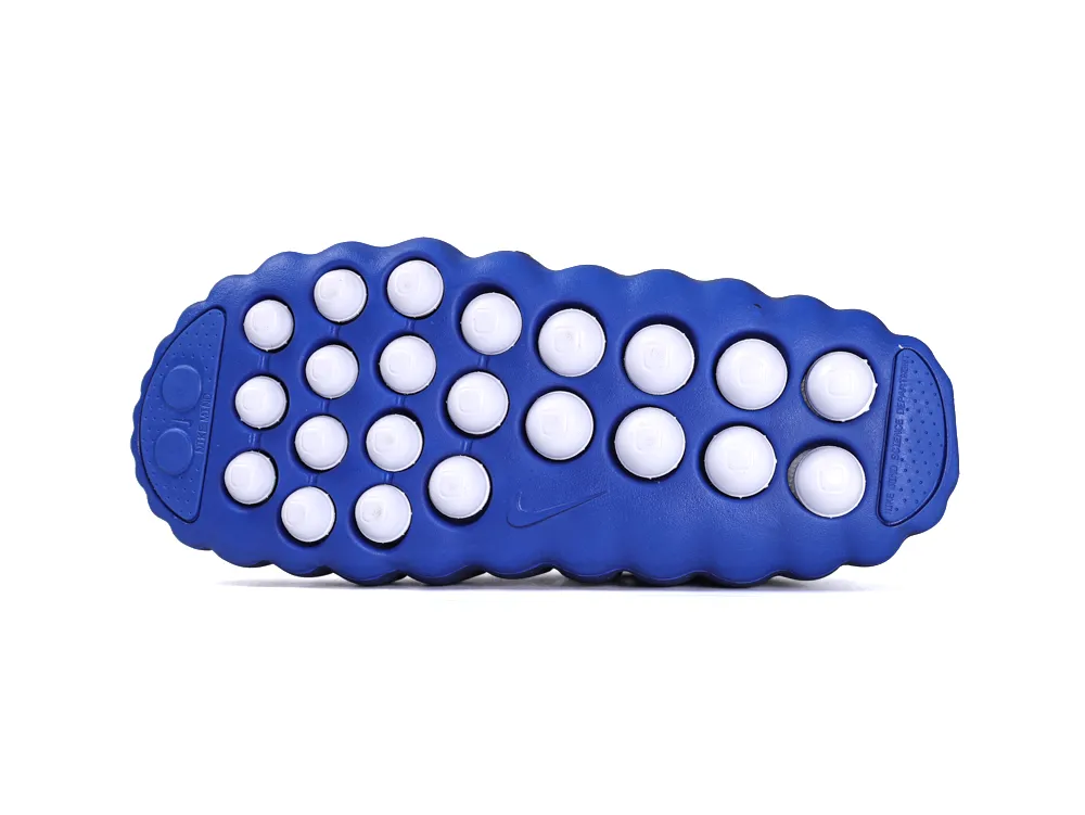 Full view of the royal blue rubber outsole featuring unique white circular traction pods.