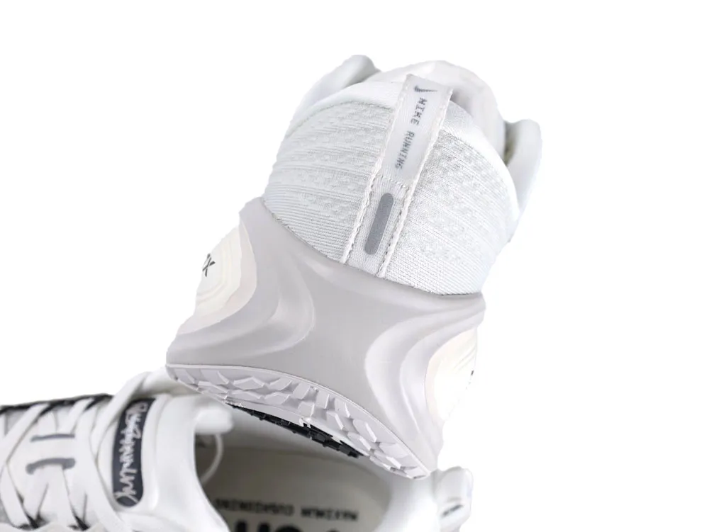 White and grey mesh and rubber sneaker heel detail with textured sole.
