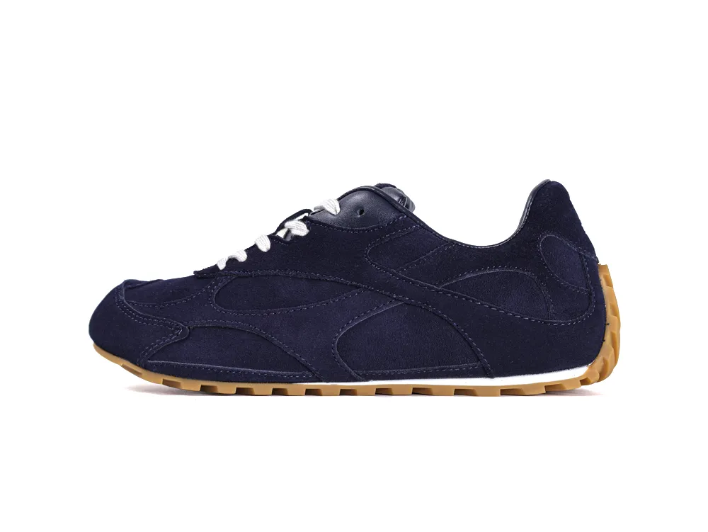 Dark blue suede sneaker with white laces and a gum rubber sole.