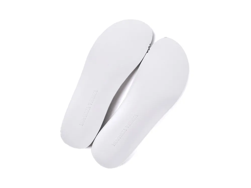 Pair of white leather insoles with the Bottega Veneta brand name embossed at the heel.