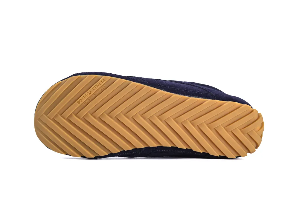 Tan rubber sole with herringbone pattern on a navy shoe.