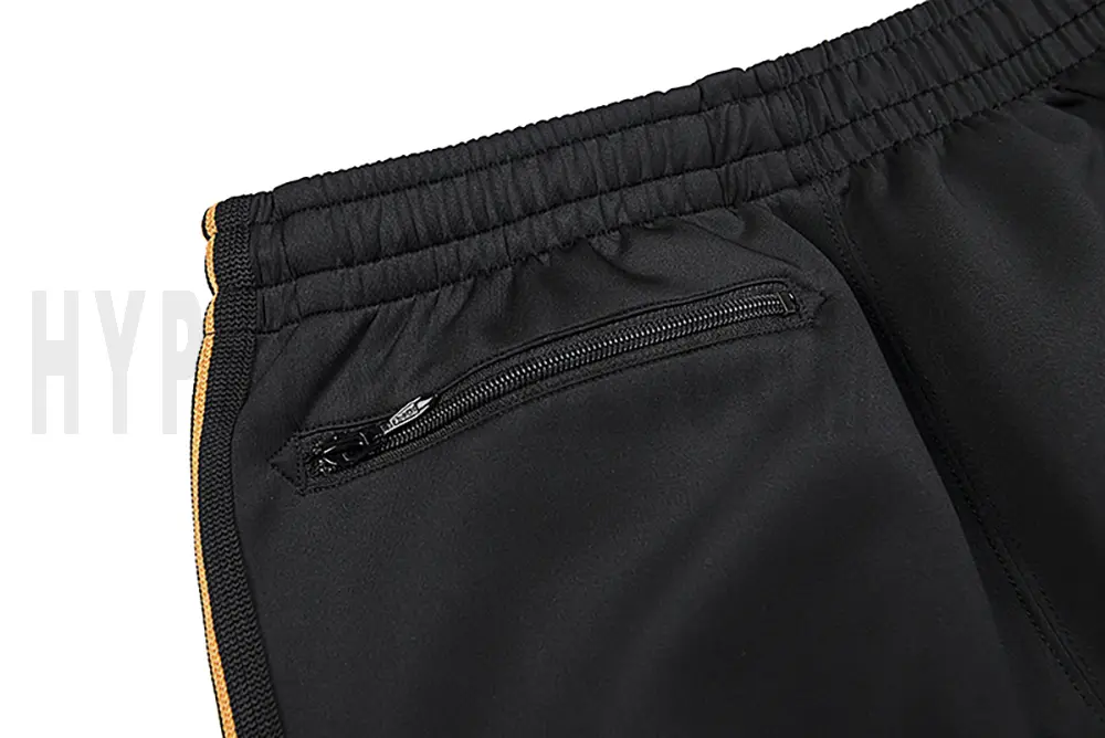 Detail of the back zip pocket on the track pants.