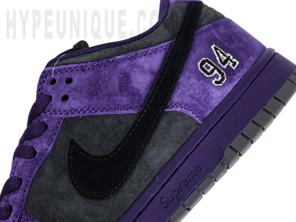 Lateral side of the shoe featuring a black Swoosh and purple suede upper.