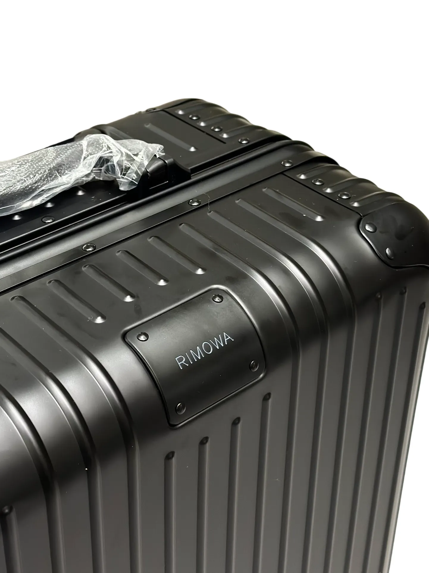 Black aluminum luggage logo detail