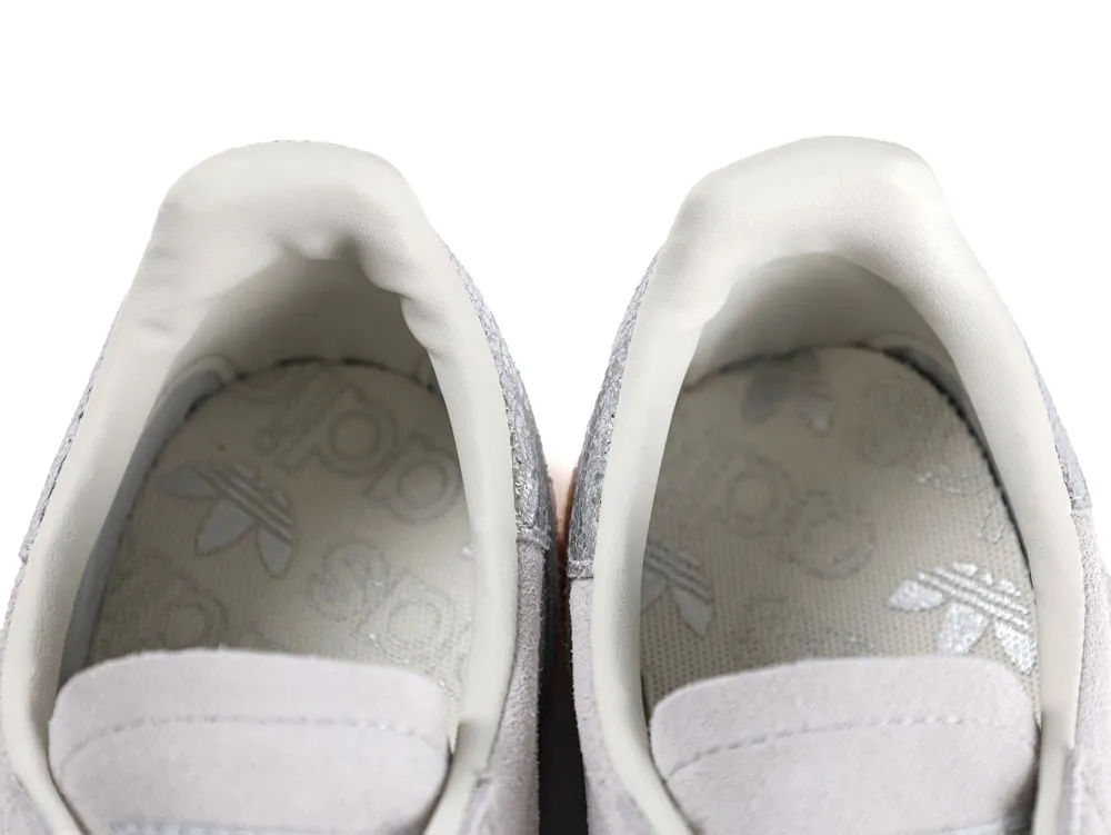 Gray suede sneakers with white leather lining and printed insoles featuring a logo.