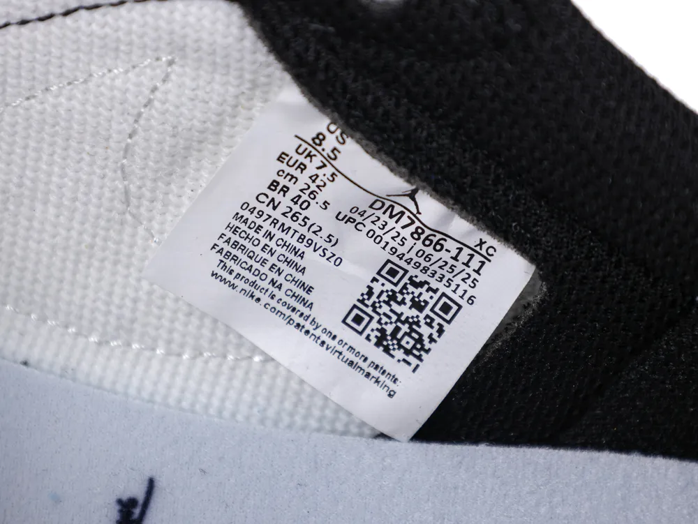 Fabric shoe tongue in black and white with visible product label and QR code.