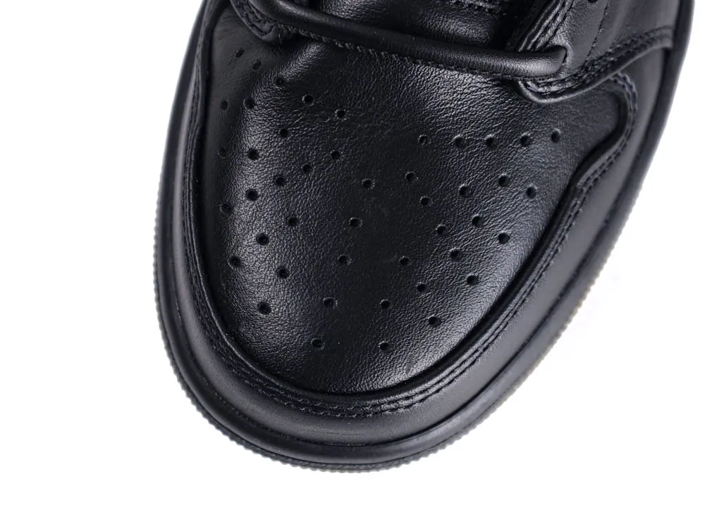 Close-up of black leather shoe toe with perforated detailing.