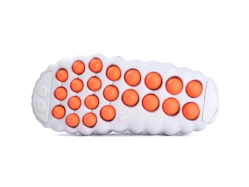 White rubber sole with orange circular patterns, featuring textured grip details.