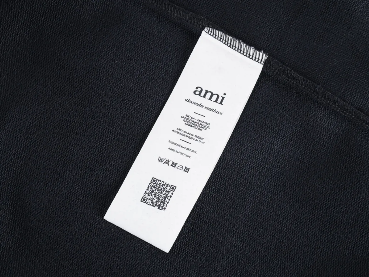 White clothing label attached, featuring brand details.