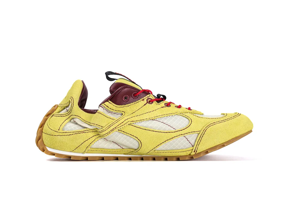 Yellow suede sneaker with red laces, burgundy accents, and a textured sole.