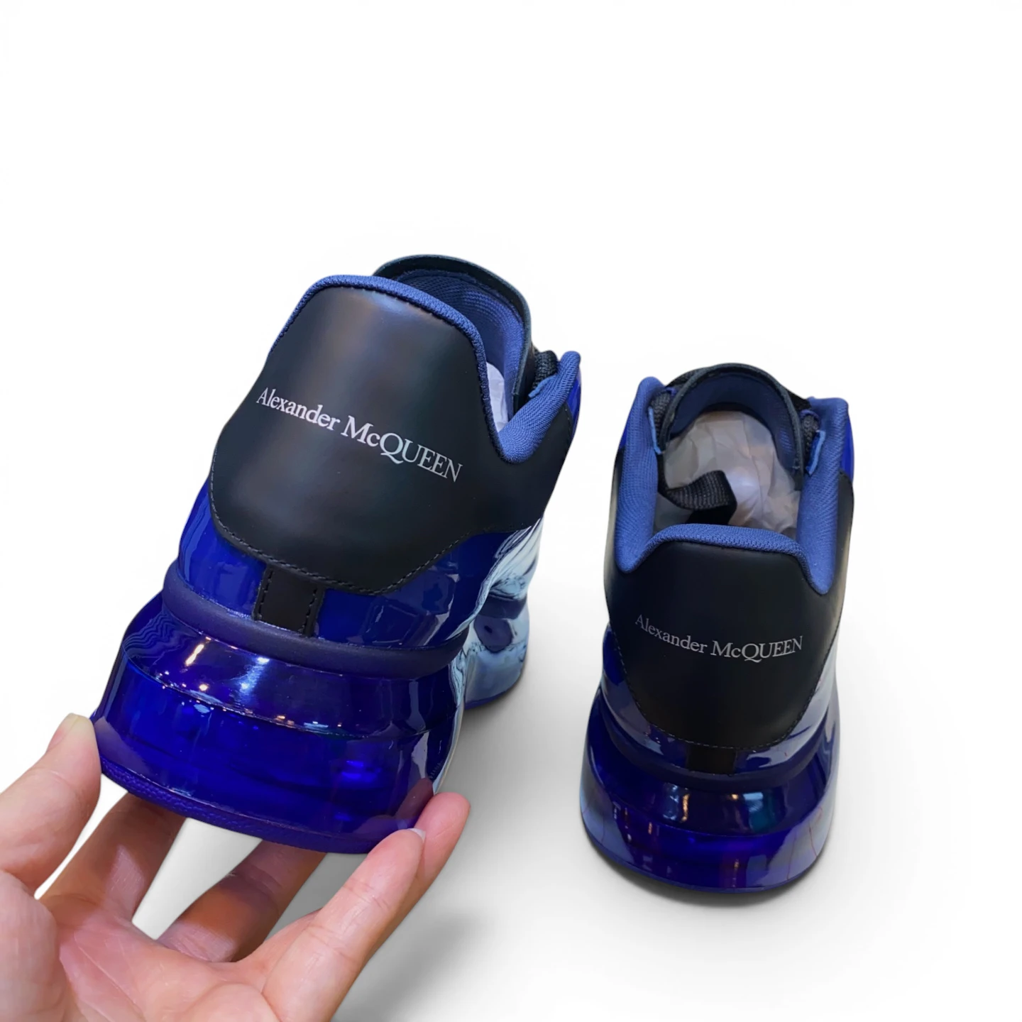 Blue and black sneakers with glossy material and prominent heel design.