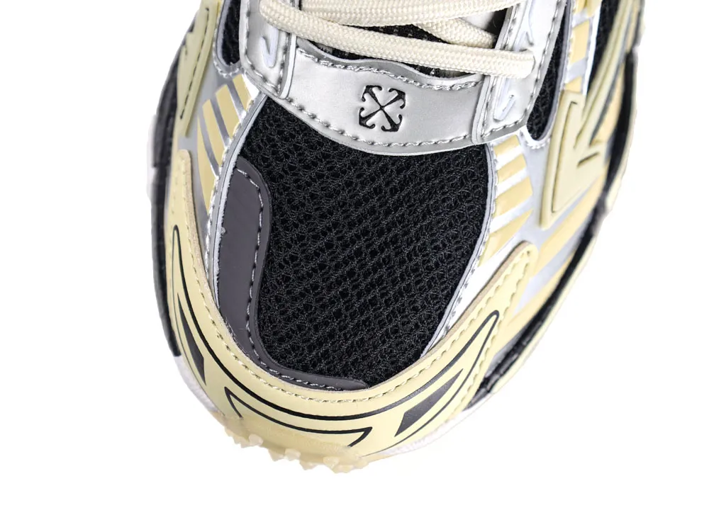 Close-up of sneaker's black mesh toe with beige and silver leather accents.