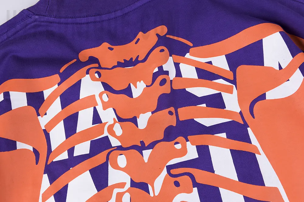 Close-up view of the blue and orange logo details on the That’s A Awful Lot of Cough Syrup Skull Ribs T-shirt.