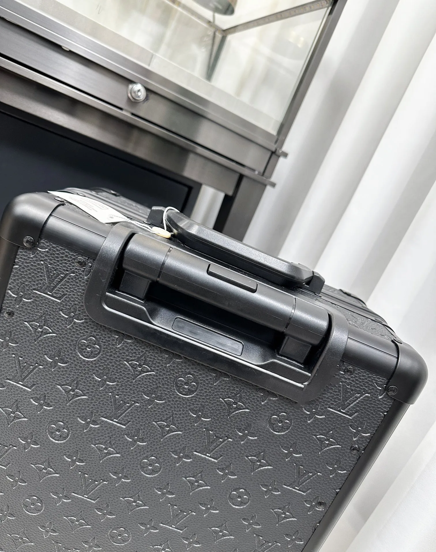 Black embossed monogram luggage top handle detail