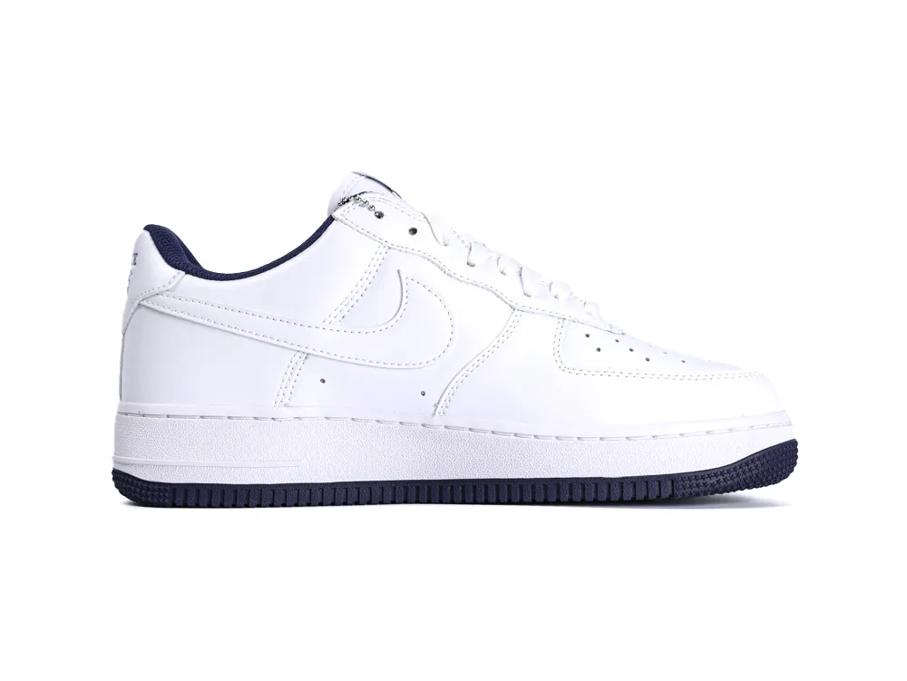 White leather sneaker with black rubber sole and perforated details on upper.