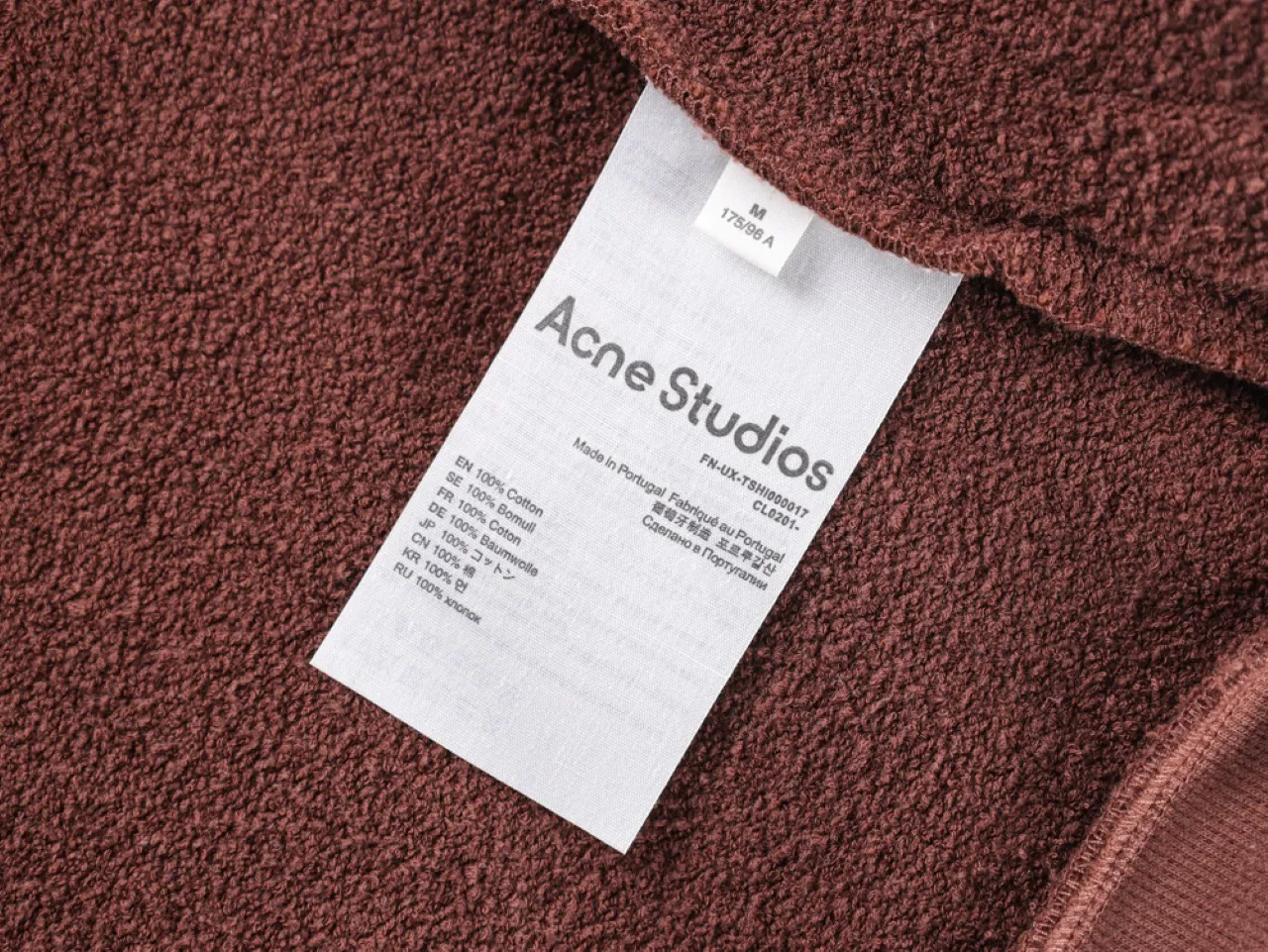 Brown textured cotton fabric with a visible tag.