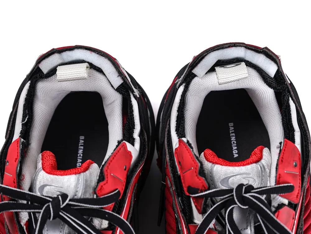 Red and black sneakers with fabric lining and black laces, top view.